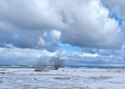 The Lake Michigan shoreline, lots of snow and ice, some fluffy grey clouds